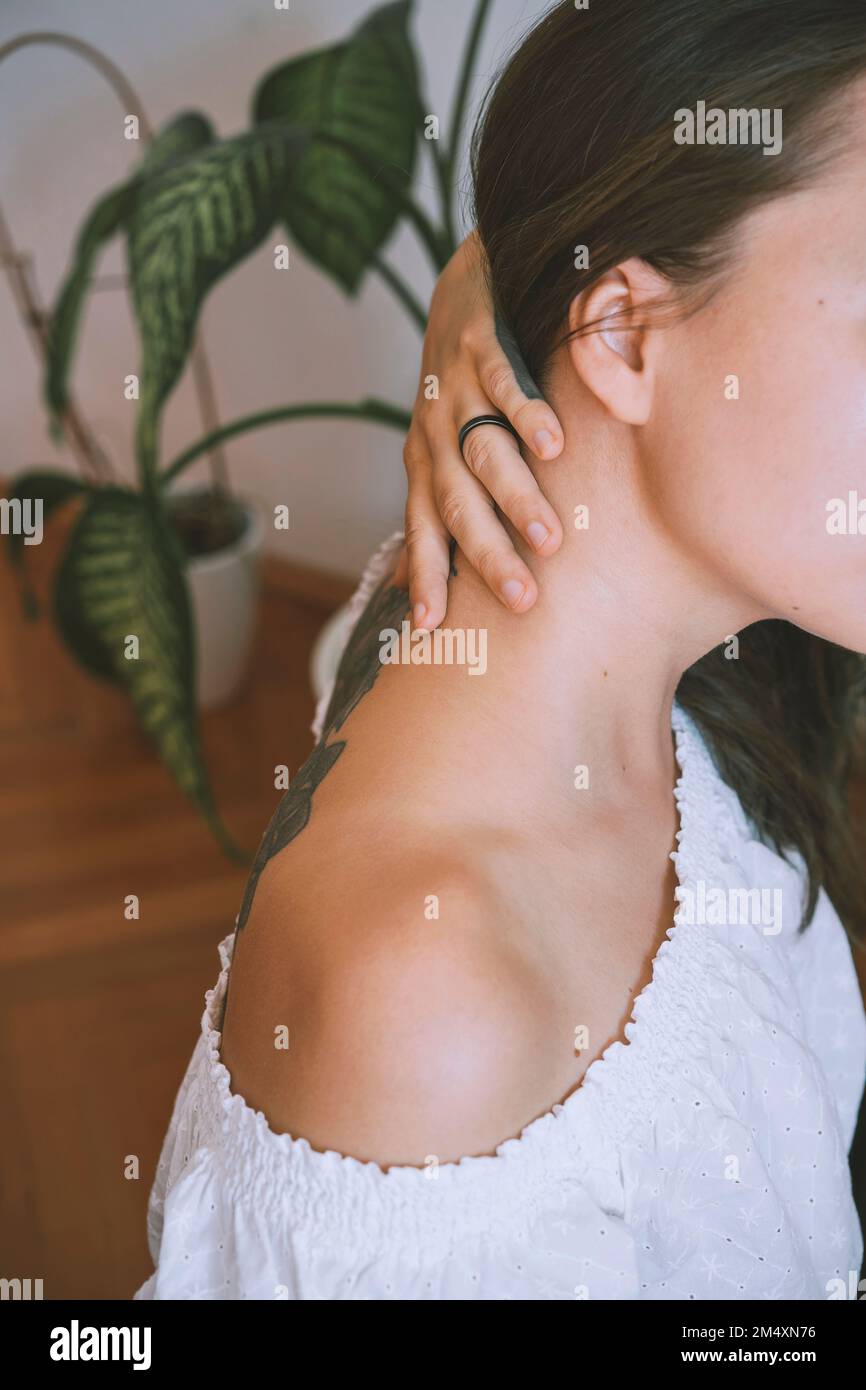 Eine Frau, die ein Schulteroberteil trägt und den Hals zeigt Stockfoto