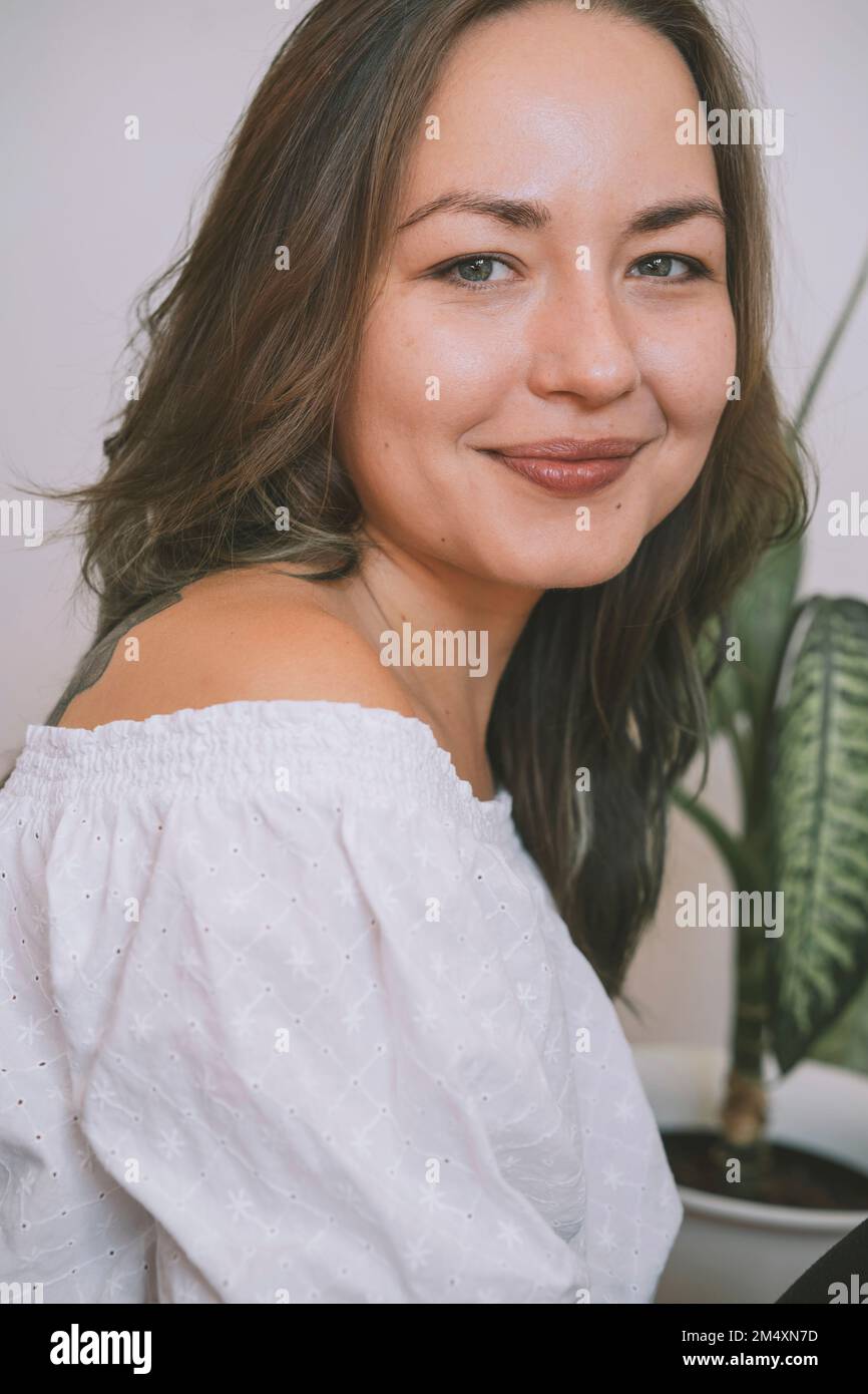 Lächelnde, wunderschöne Frau in weißem Schulteroberteil Stockfoto