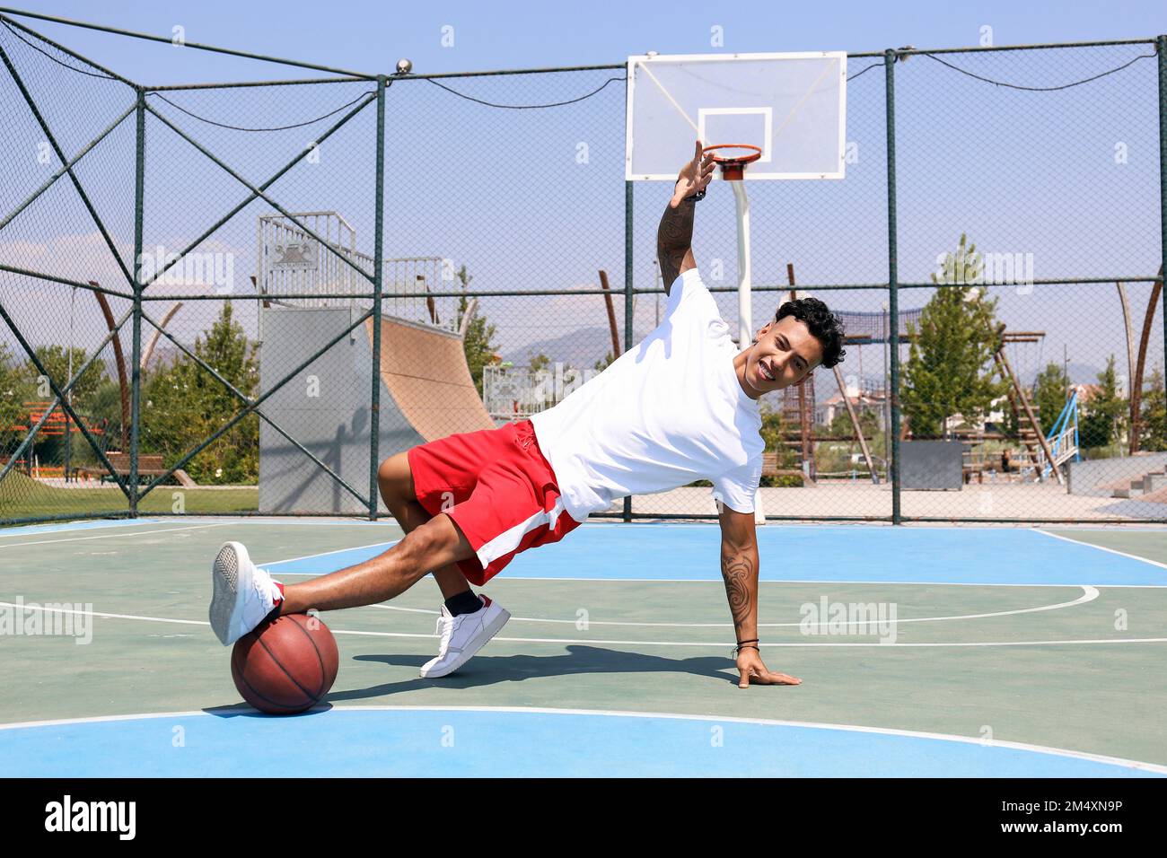 Ein Mann, der Tanzbewegungen mit Basketball auf dem Sportplatz trainiert Stockfoto