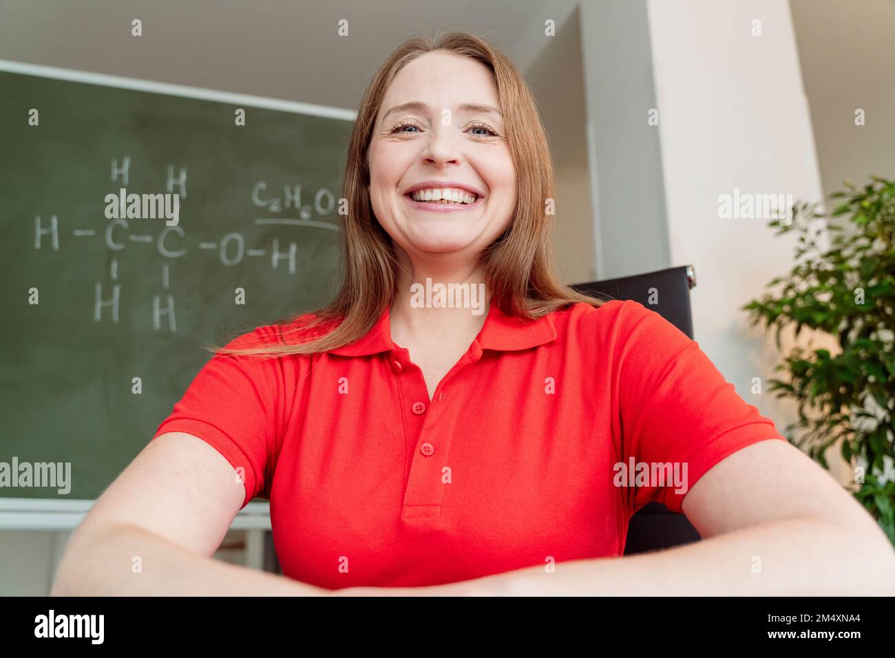 Glücklicher Chemielehrer mit rotem Poloshirt Stockfoto