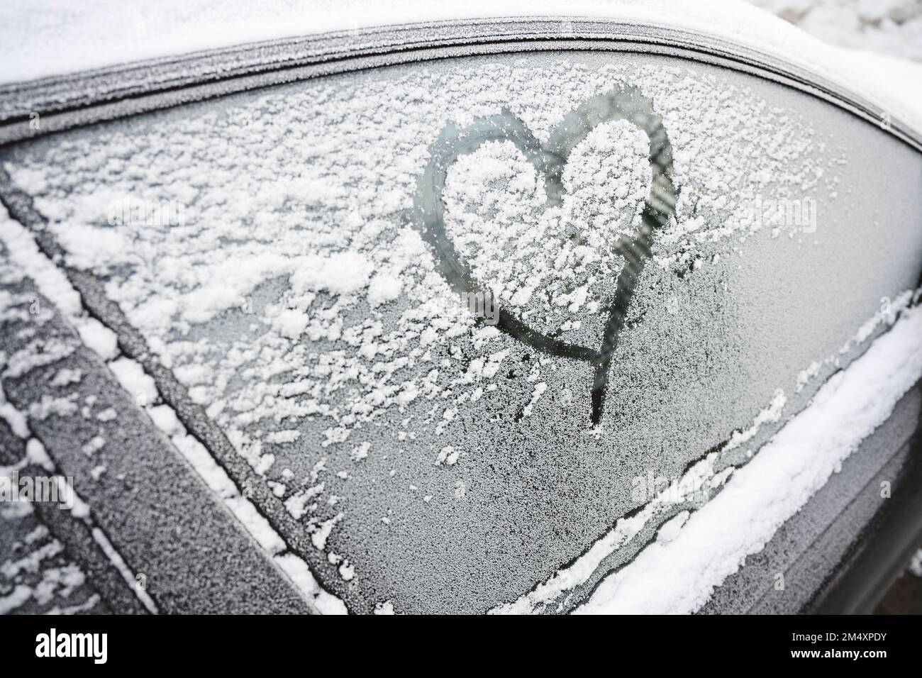 Herzform auf mattem Autofenster im Winter Stockfoto