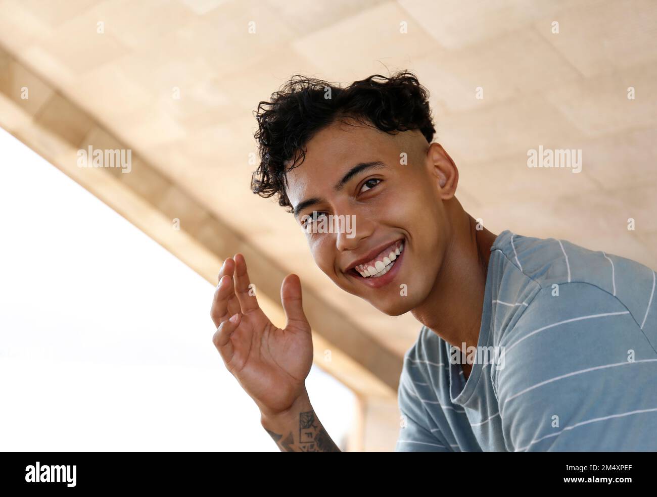 Glücklicher junger Mann mit unordentlichem Haar Stockfoto
