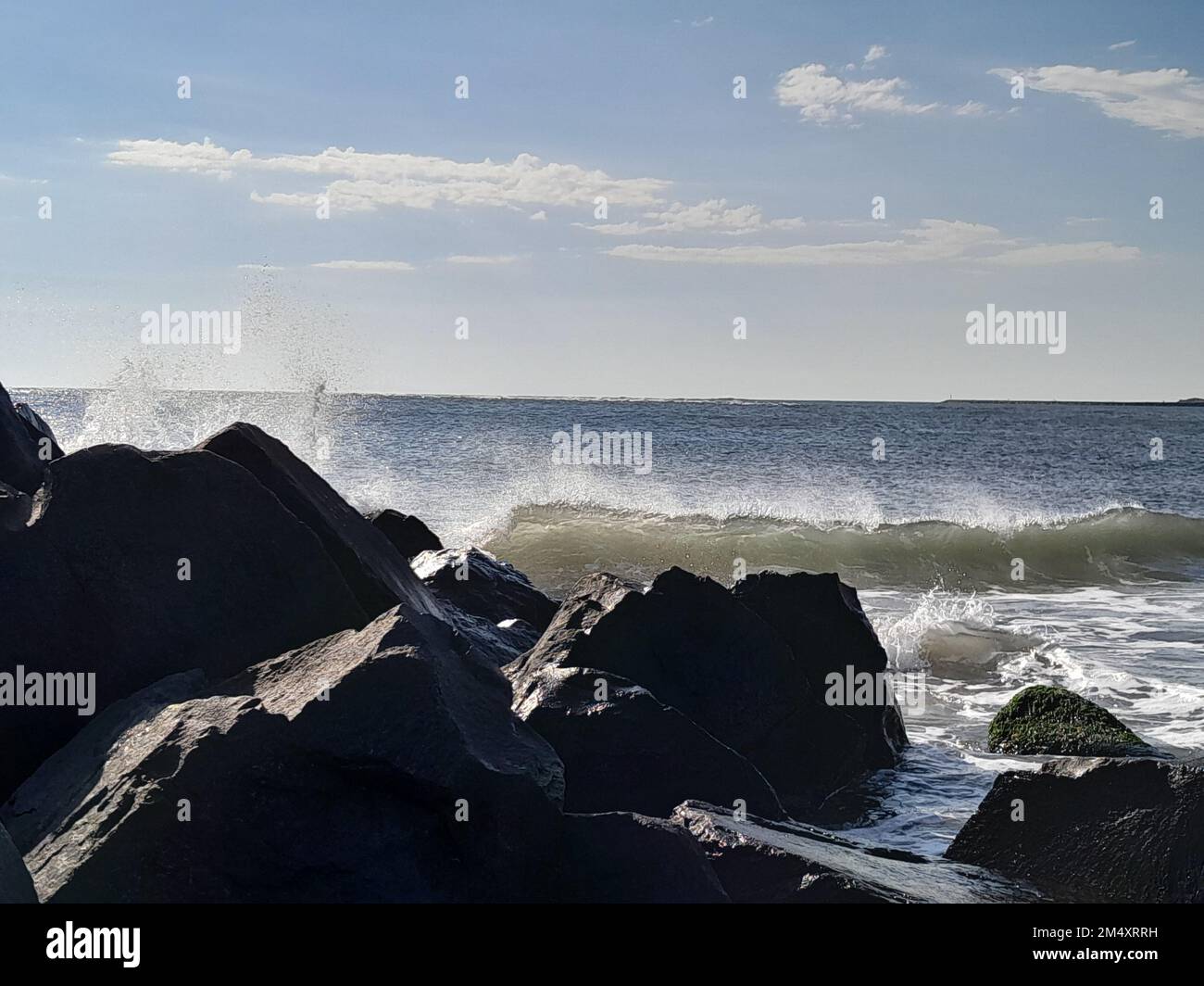 Es war ein windiger Tag am Ufer, und ich habe ein Bild von brechenden Wellen gefangen, als sie auf die Felsen stießen. Dieser Teil des Strandes liegt in der Nähe von Sea Isle City NJ Stockfoto
