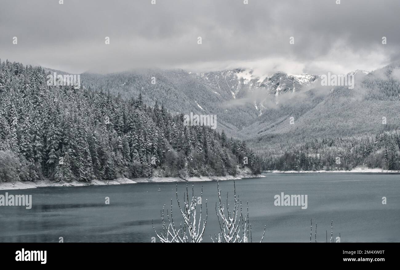 Der Capilano Lake im Capilano River Regional Park in North Vancouver, British Columbia, Kanada, ist von einer wunderschönen verschneiten Winterlandschaft umgeben Stockfoto