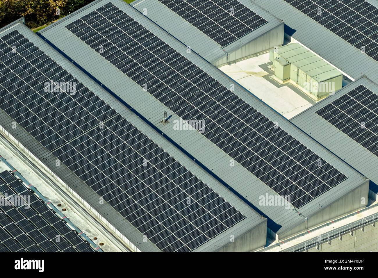 Luftaufnahme von blauen Photovoltaik-Solarmodulen, die auf dem Dach eines Industriegebäudes montiert sind, um ökologischen Ökostrom zu erzeugen. Produktion von Sustainabl Stockfoto