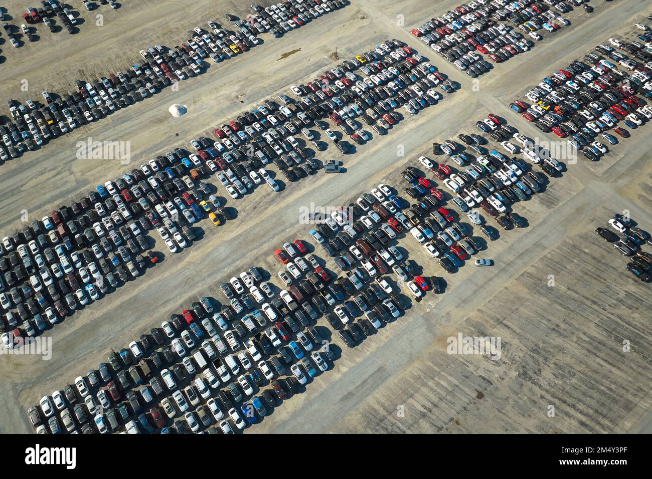 Blick von oben auf den großen Parkplatz mit abgestellten Gebrauchtwagen nach Unfall zum Verkauf bereit. Auktionshändler, der gebrauchte kaputte Fahrzeuge verkauft Stockfoto