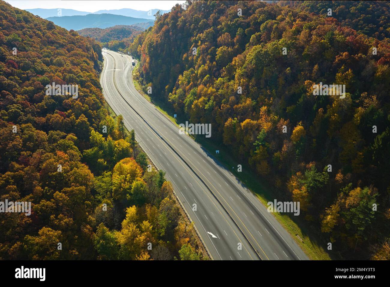 Blick von oben auf die leere, verlassene Autobahn I-40 in North Carolina, die nach Asheville durch die Appalachen mit gelben Herbstwäldern führt. Interst Stockfoto