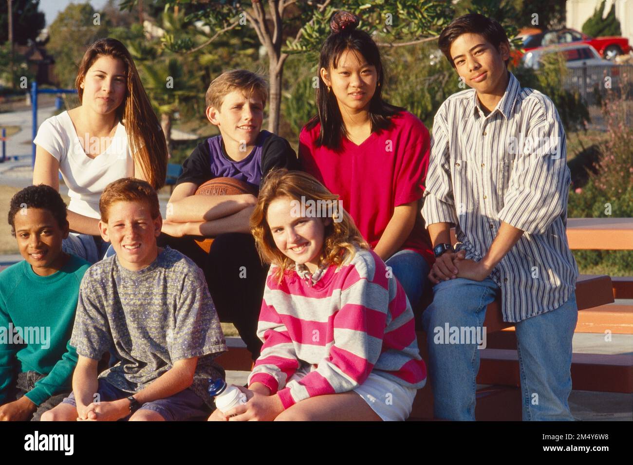Eine Gruppe von Teenagern, die auf einem Picknicktisch sitzen und für ein Foto posieren Stockfoto