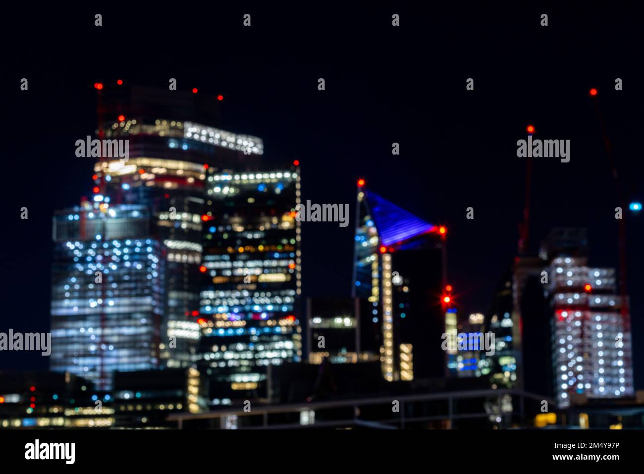 Verschwommenes Bild des Nachtlebens in London, geschäftiger Verkehr auf der Brücke über die Themse in der Nähe des Geschäftsviertels mit glitzernden Wolkenkratzern Stockfoto
