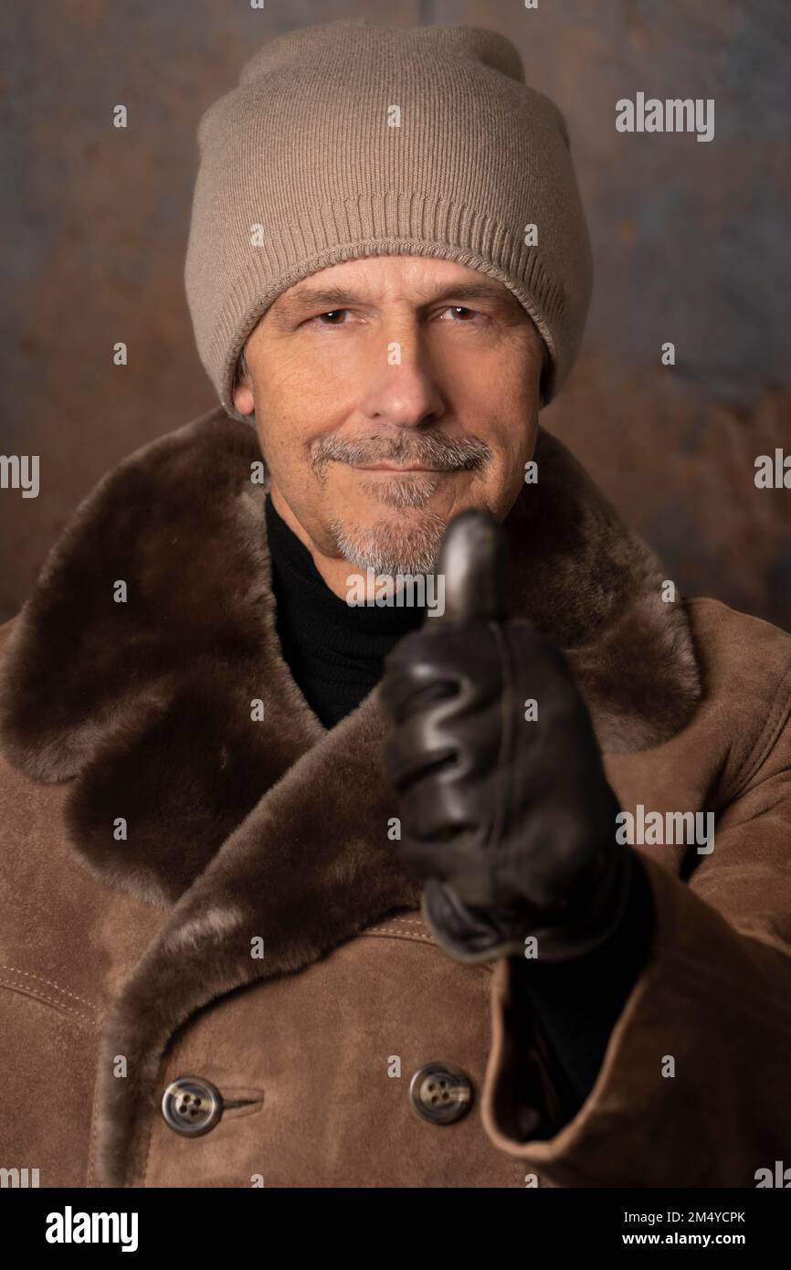 Älterer Mann in Winterkleidung, Daumen hoch Stockfoto