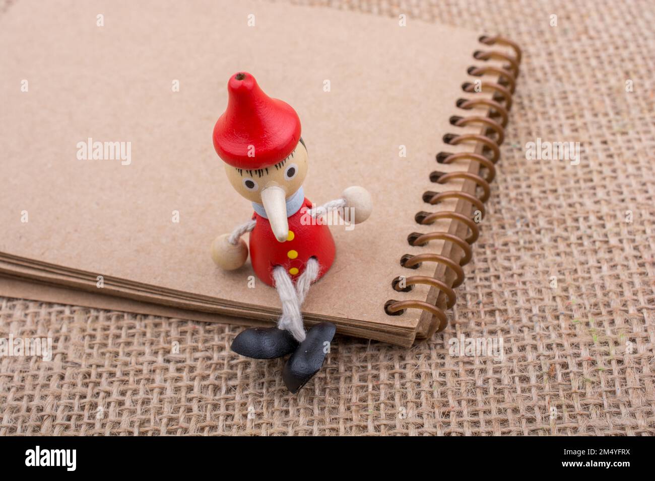 Pinocchio sitzen am Notebook auf eine Leinwand-Hintergrund Stockfoto