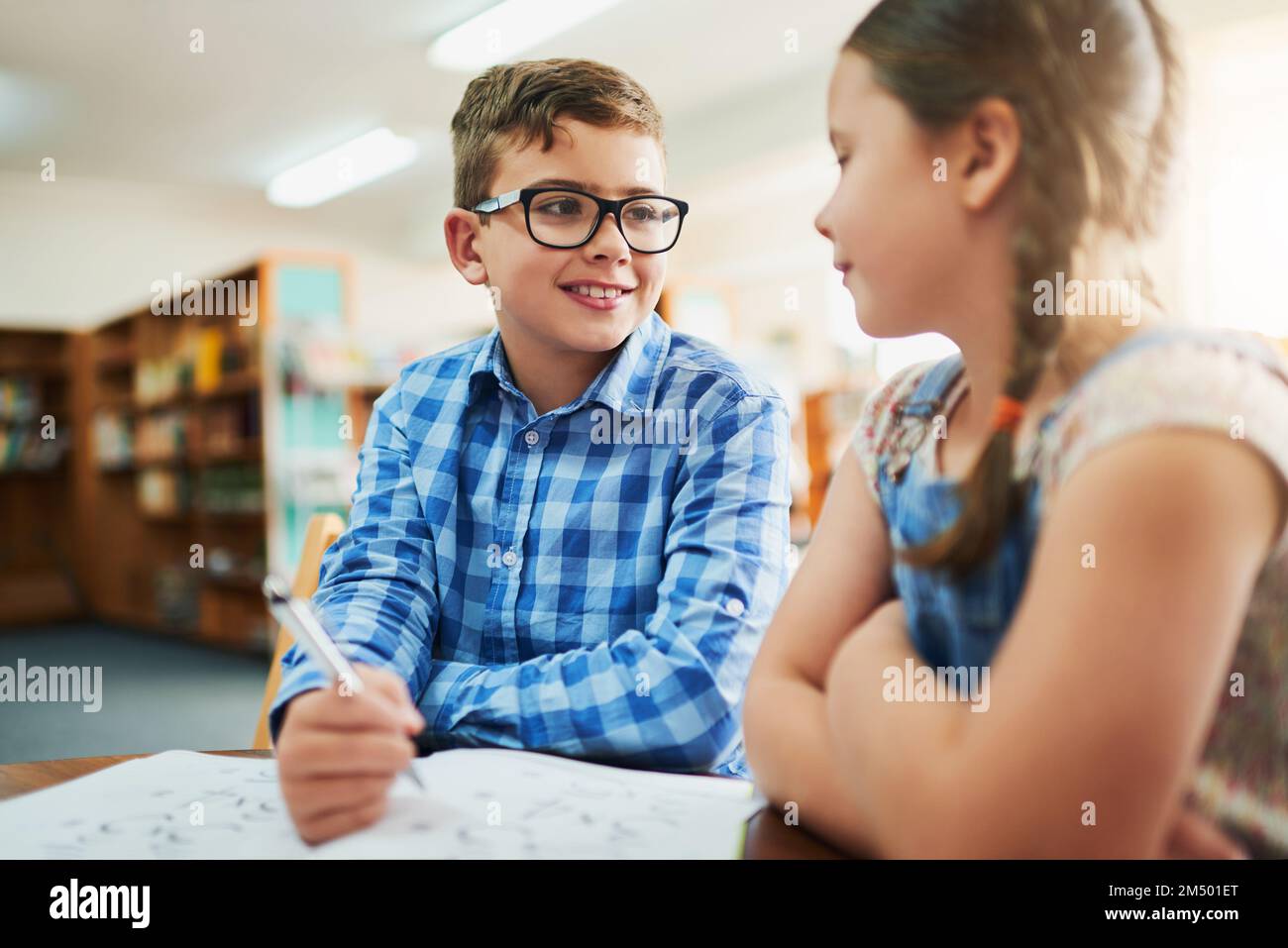 Je mehr Hilfe, desto besser. Zwei kleine Kinder arbeiten tagsüber in einem Klassenzimmer zusammen. Stockfoto