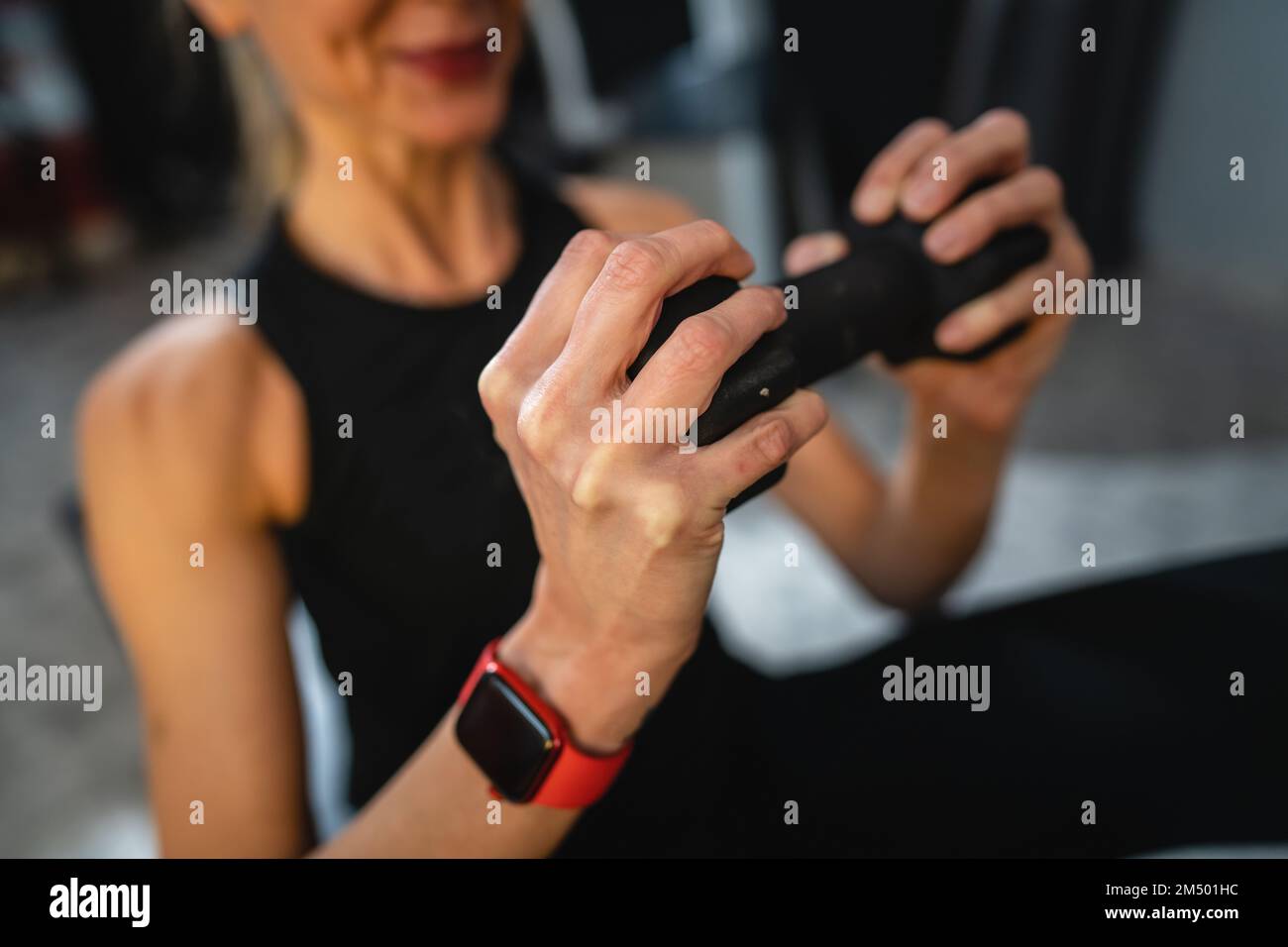 Eine Frau reife weiße weibliche schlanke Hände halten die Kurzhantel, während sie zu Hause oder im Fitnessstudio trainieren echte Menschen gesunde Lebensweise Konzept kopieren Stockfoto