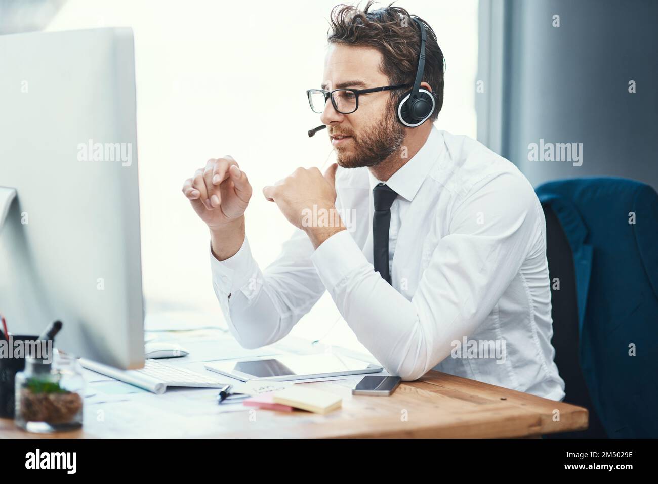 Seinen Klienten sorgfältige Ratschläge geben. Ein Callcenter-Agent, der in einem Büro arbeitet. Stockfoto