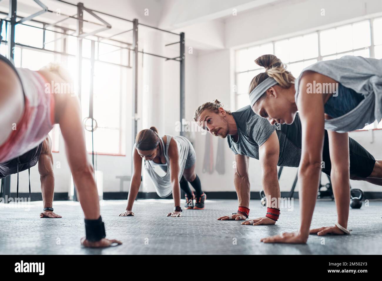 Wach auf und sei motiviert. Eine Rechenschaftspflicht-Gruppe, die Liegestütze im Fitnessstudio macht. Stockfoto
