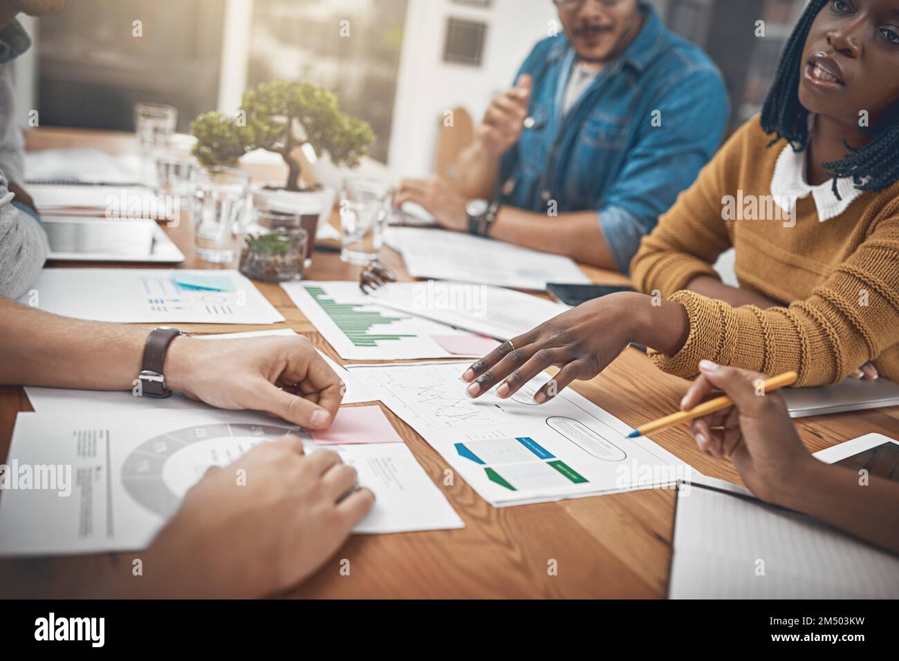 Einen Weg hin zu einer tragfähigen und nachhaltigen Lösung zu finden. Eine Gruppe von Geschäftsleuten, die Statistiken diskutieren. Stockfoto