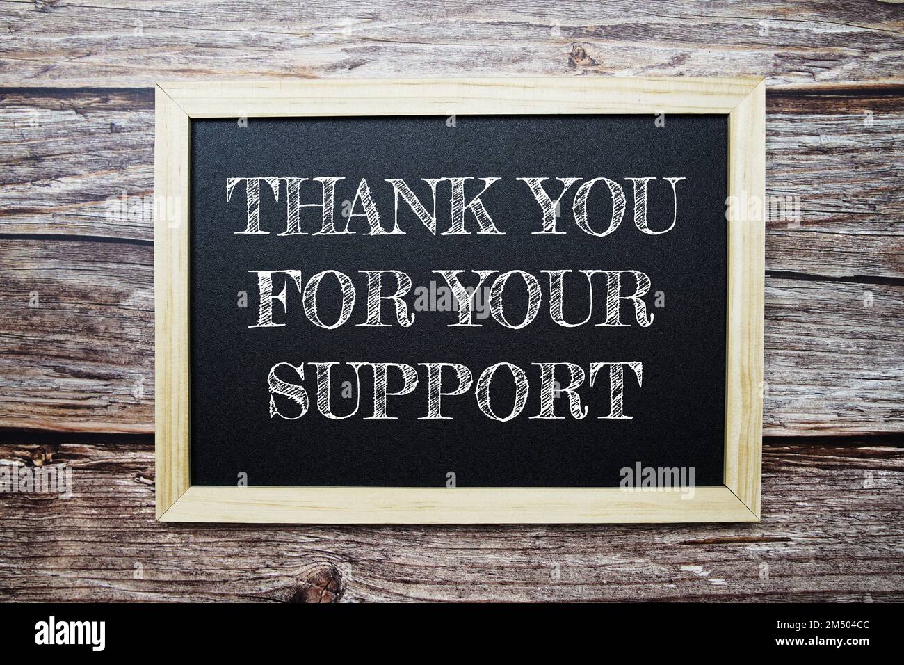 Vielen Dank für Ihr Support-Wort mit Wecker auf Holzhintergrund Stockfoto