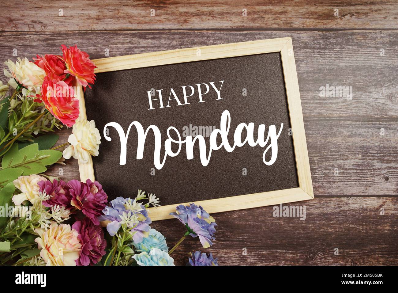 Happy Monday Typografie Text und Blumendekoration auf Tafelhintergrund Stockfoto