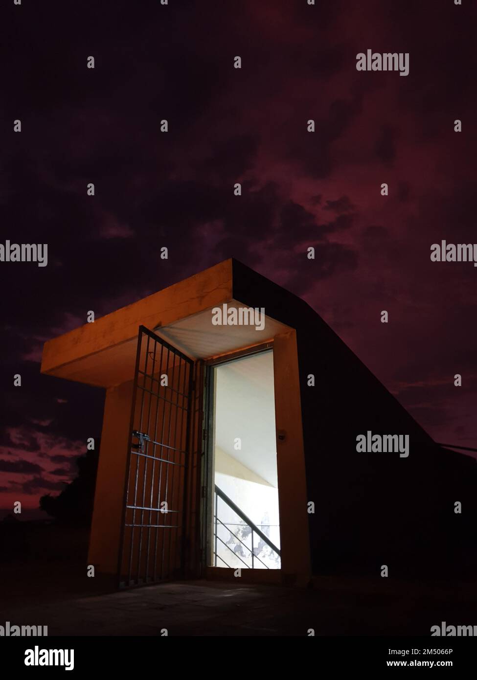 Ein vertikales Bild des Dreiecksgebäudes mit einem Gefängnistor anstelle einer Tür bei Sonnenuntergang Stockfoto