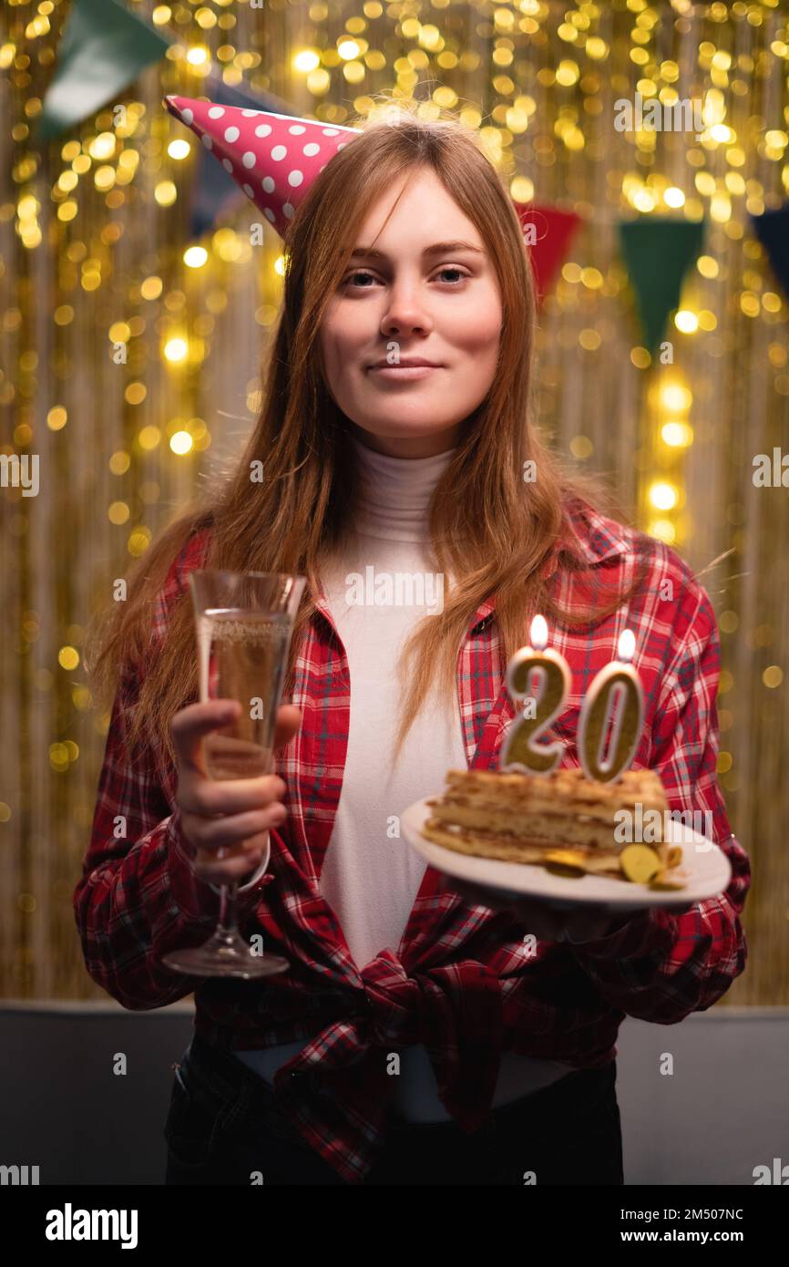 Geburtstagsfeier. Alles gute zum Geburtstag. Aufgeregte, wunderschöne Frau hält einen köstlichen Kuchen mit Kerze Nummer 20 und lächelt, während sie ihre BI feiert Stockfoto