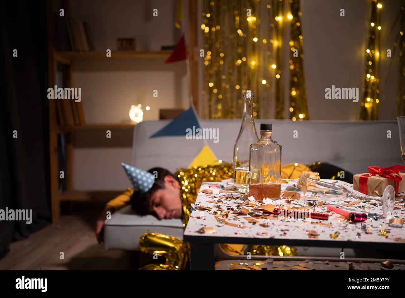 Betrunkener Mann, der nach der Party zu Hause auf dem Sofa schläft. Speicherplatz kopieren Stockfoto