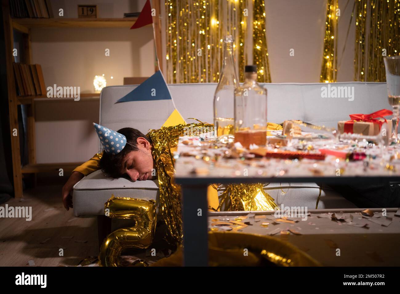 Betrunkener Mann schläft nach einer Party auf dem Sofa nach einer Party zu Hause. Speicherplatz kopieren Stockfoto