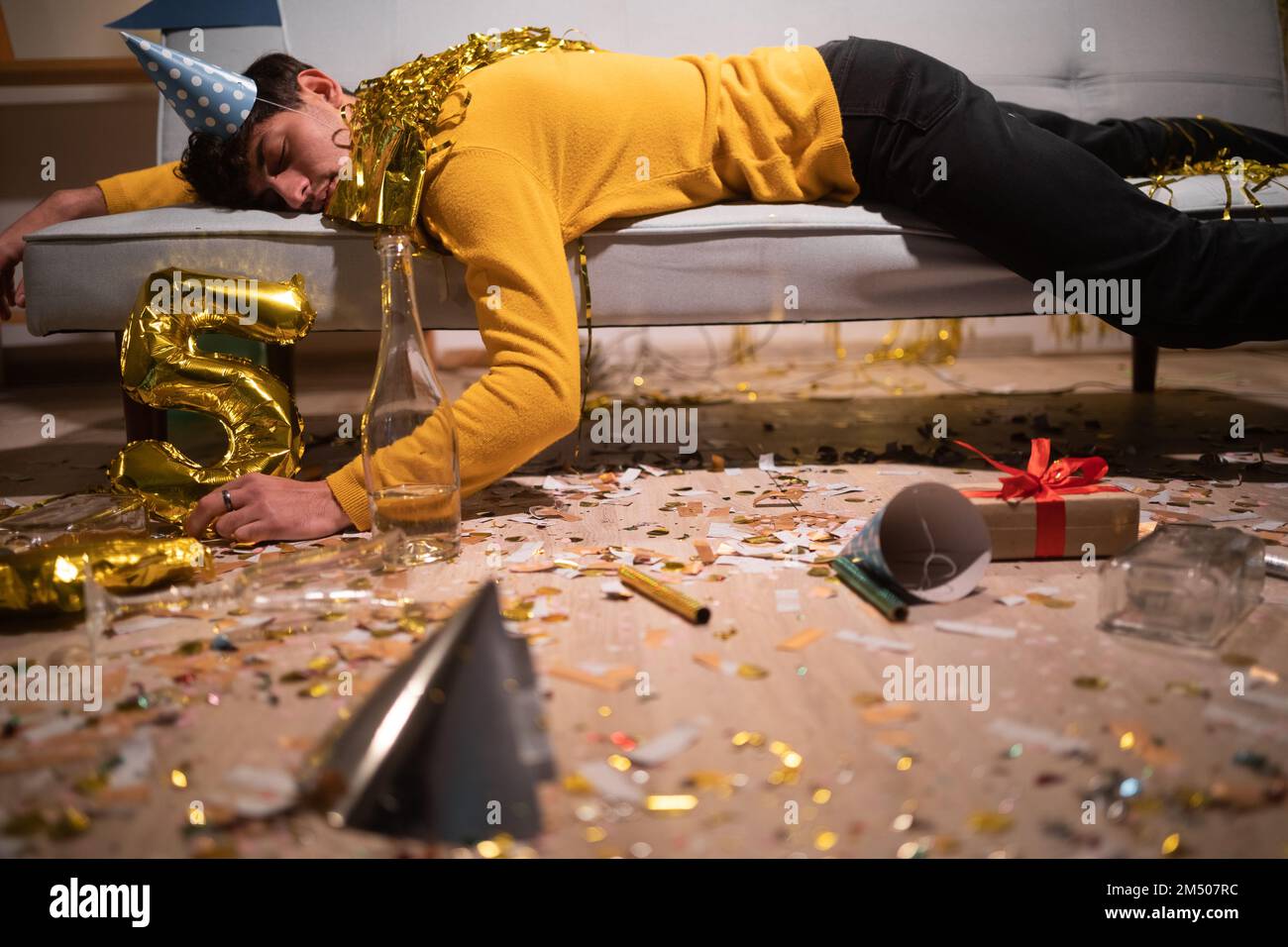 Betrunkener Mann schläft nach der Geburtstagsparty im Zimmer. Speicherplatz kopieren Stockfoto