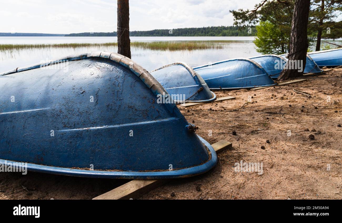 Blaue Ruderboote lagen Kopf über Kopf an einem Sandstrand Stockfoto