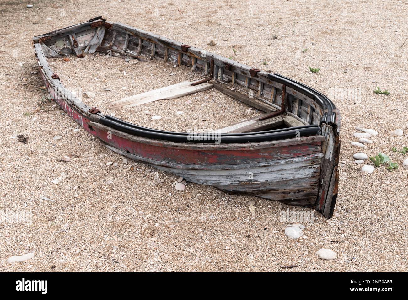 Ein kaputtes verlassenes Holzboot liegt tagsüber am Strand Stockfoto