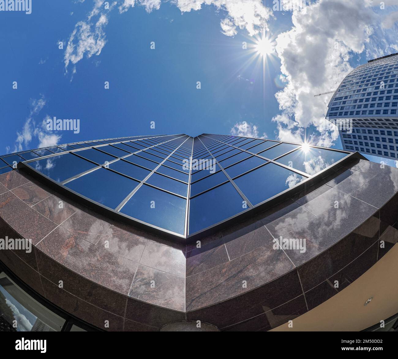 Ein schwacher Fokus eines Glasgebäudes in der Innenstadt von Bellevue in Washington, mit Sonnenlicht an einem wolkigen Himmel im Hintergrund Stockfoto