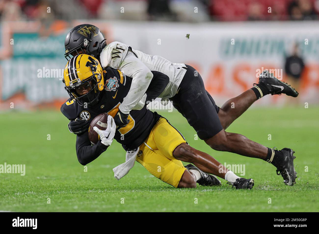 Tampa Bay, Florida, USA; Missouri Tigers Wide Receiver Mookie Cooper (5) nimmt den Empfang wahr und wird während der Union Home Mortgage Gasparilla Bowl g angesprochen Stockfoto