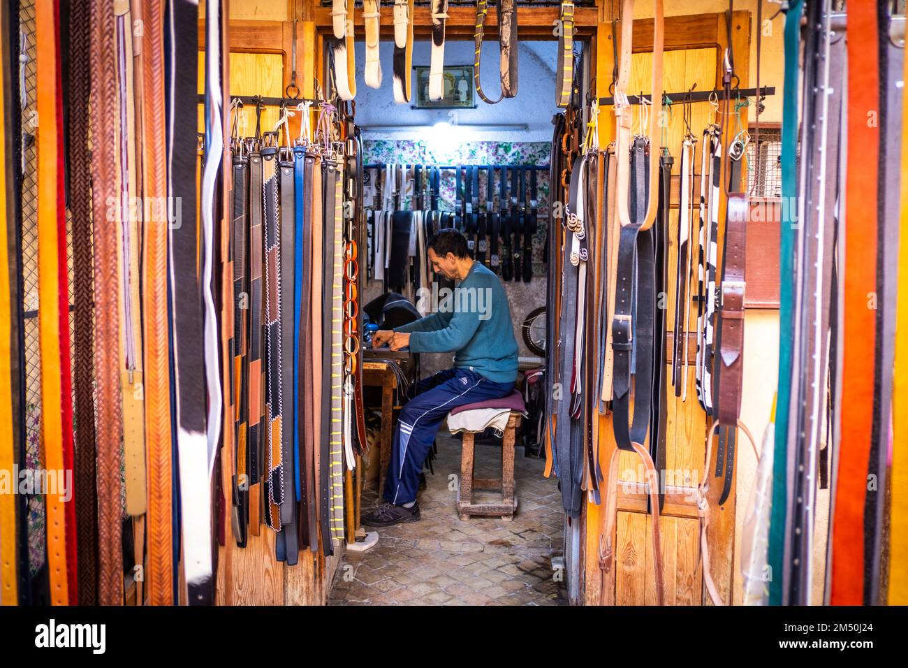 Fes, Marokko; 7. dezember 2022: Ein Lederhandwerker arbeitet in seiner Werkstatt in der Medina. Fes-Leder ist für seine hohe Qualität und Weichheit bekannt. Stockfoto