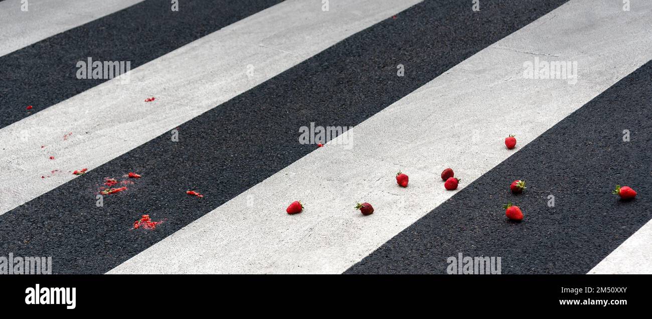 Erdbeeren auf einem Fußgängerüberweg zerquetscht Stockfoto