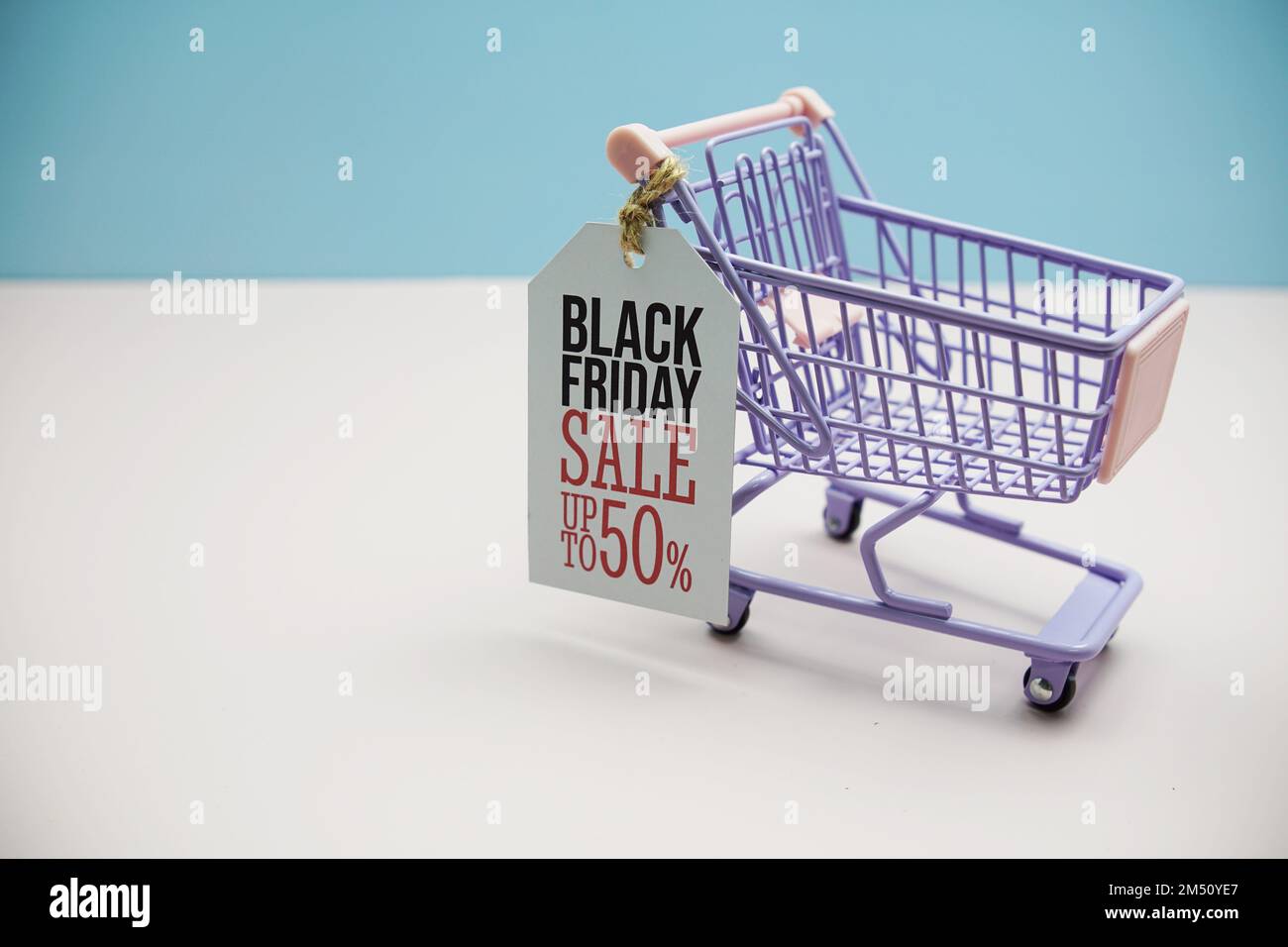 Black Friday Salee 50 % Textnachricht zur Preissteuer mit Einkaufswagen auf blauem und pinkfarbenem Hintergrund Stockfoto