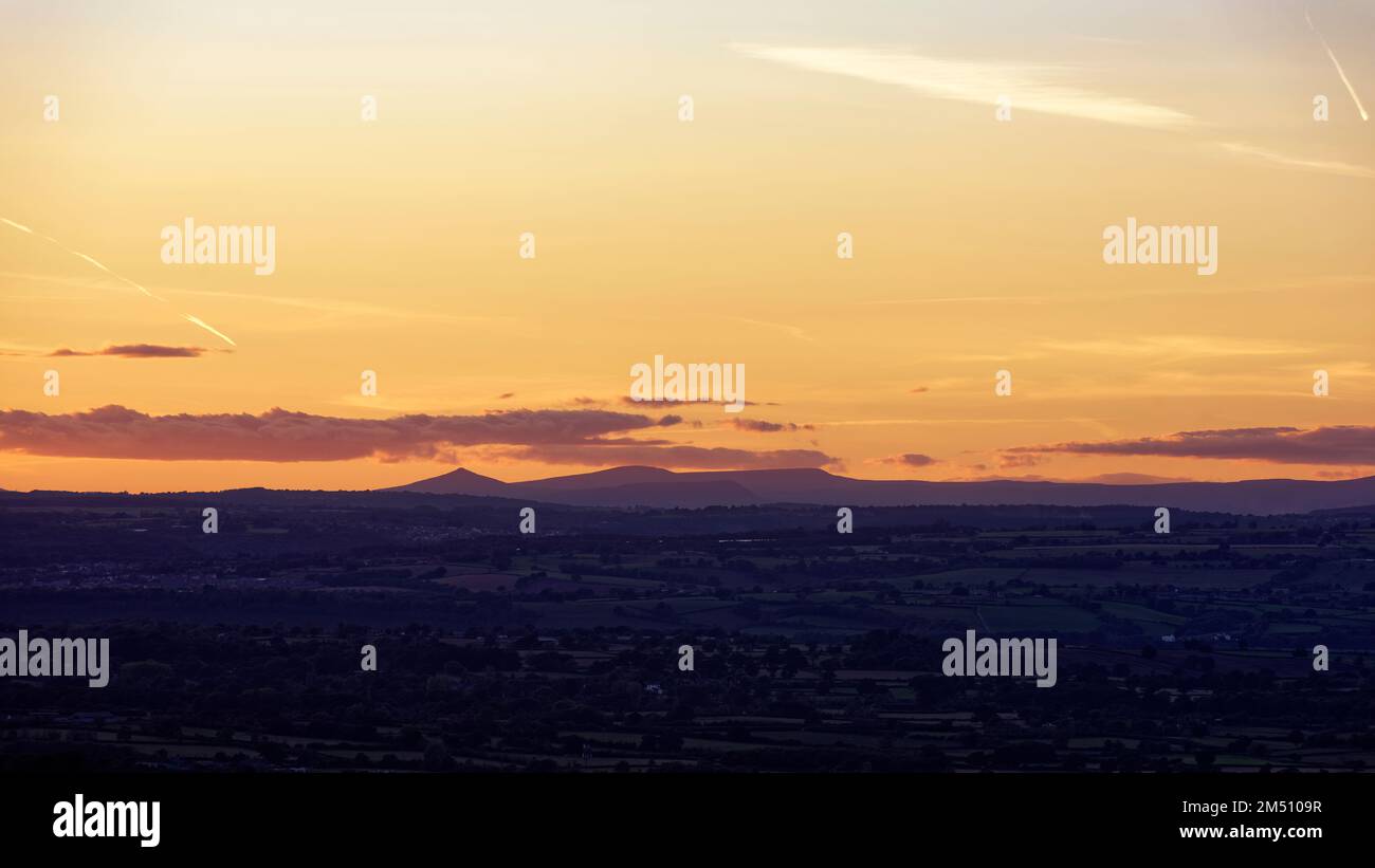 Sonnenuntergang über den Brecon Beacons von Cam Long Down, Dursley, Gloucestershire, Großbritannien Stockfoto