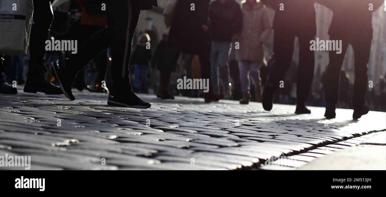 Menschen in einer überfüllten Einkaufsstraße in europa. Geschäftiges Alltagsleben in Großstädten mit historischem Ambiente auf Kopfsteinpflasterstraßen. Stockfoto