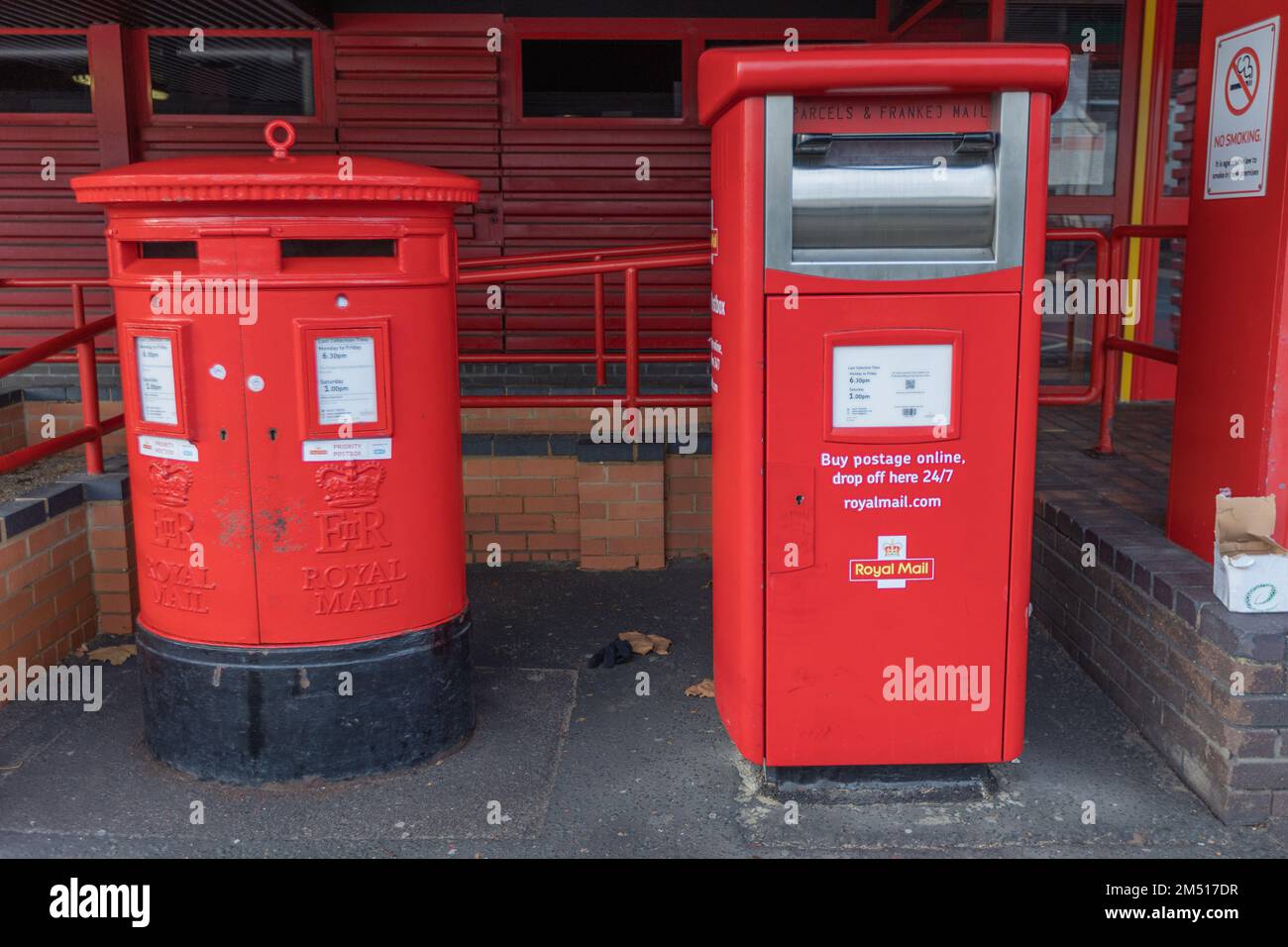 Southend on Sea, Großbritannien. Dezember 2022. Das Royal Mail Delivery Office und das Postzentrum sind in Southend aufgrund von Arbeitskampfmaßnahmen der Communication Workers Union geschlossen. Wo Royal Mail Postfächer vor einem rothäfelten Gebäude in Großbritannien. Die linke Box hat ein traditionelles zylindrisches Design mit zwei Postfächern und Royal Mail-Insignien. Die rechte Box ist eine moderne rechteckige Einheit mit einem digitalen Bildschirm und Beschilderung, die 24/7 Online-Postdienste fördert. Die Gegenüberstellung verdeutlicht die Entwicklung der britischen Postversammlungssysteme. Penelope Barritt/Alamy Live News Stockfoto