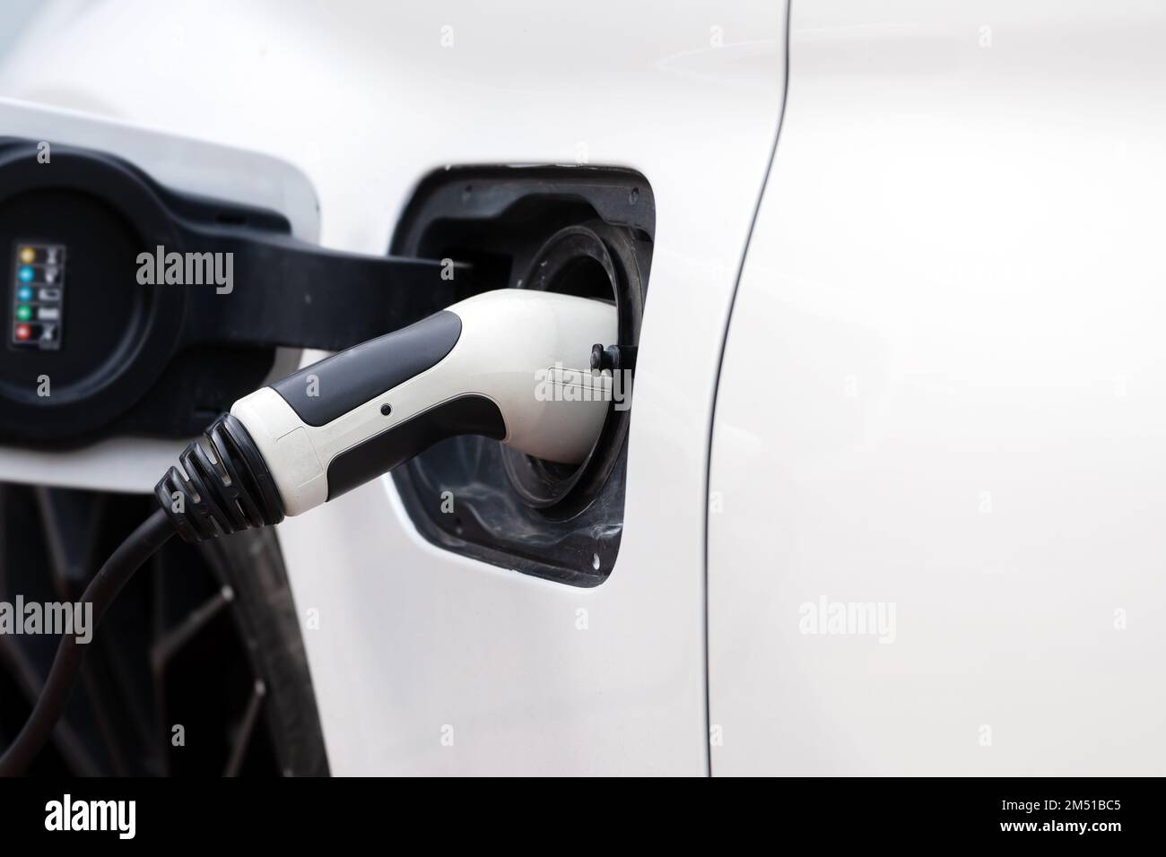 Das Stromkabel ist mit dem Ladegerät des Elektrofahrzeugs in Nahaufnahme verbunden Stockfoto