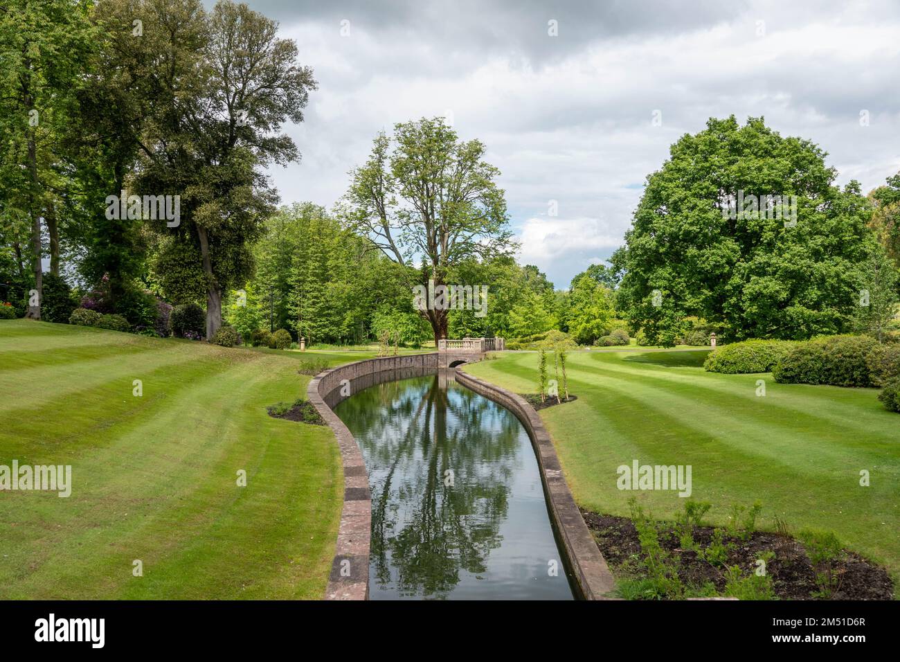 Fluss mit Reflexionen, der durch einen wunderschönen Garten in england fließt Stockfoto