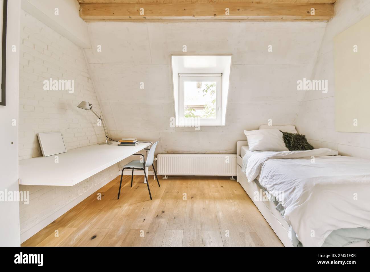Ein kleines Zimmer mit zwei Betten und einem Schreibtisch in der Ecke auf der rechten Seite ist ein Fenster mit Blick nach draußen Stockfoto