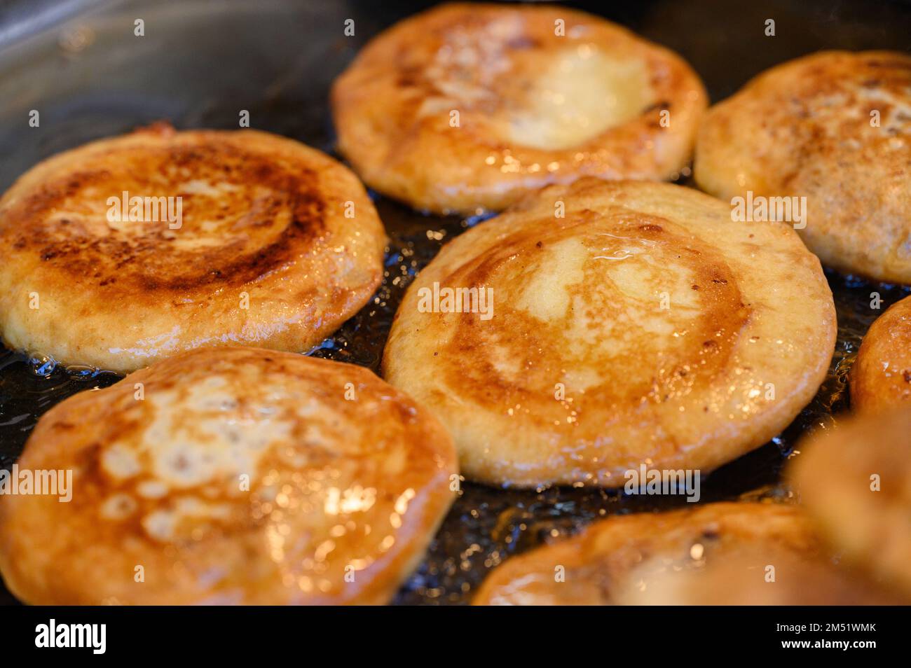 Hotteok, koreanischer, mit Sirup gefüllter Pfannkuchen : fermentierter Mehlteig in Form von Kugeln, gefüllt mit einem Löffel braunem Zucker und in der Pfanne gebraten in einem vorgewärmten Pa Stockfoto