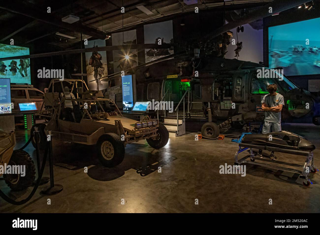 Geländefahrzeug und Hubschrauber im Navy SEAL Museum in Fort Pierce mit Videos im Hintergrund. Stockfoto