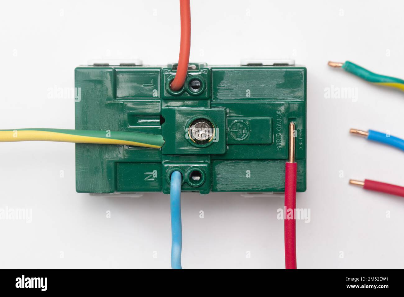 Der Elektriker verwendet das auf der Rückseite des Geräts abgebildete Bandmaß, um die korrekte Länge des Kabels zu messen. Stockfoto