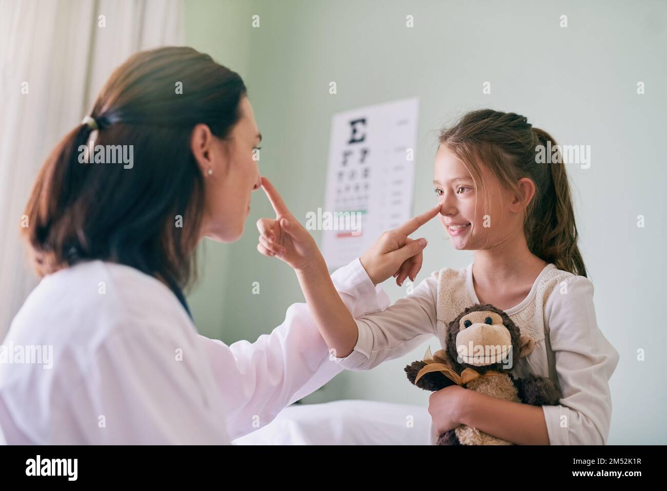 Kinderfreundliches Gesundheitswesen. Eine freundliche Ärztin, die vor ihrem jungen Patienten sitzt. Stockfoto