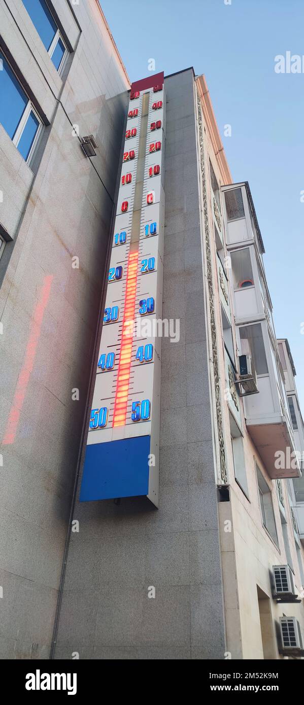 Ein Thermometer auf der Straße an der Wand des Hauses zeigt eine Temperatur von -13 Grad Celsius. Kalter Winter Stockfoto