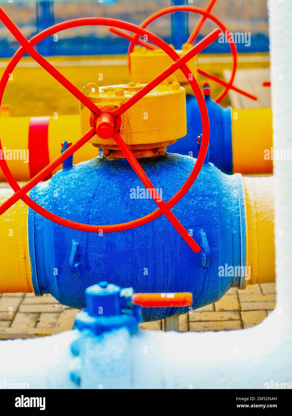 Industrieller Hintergrund. Die Gasleitung ist gelb mit zusätzlichen Anlagen, Rohren und einem Ventil zum Absperren der Gasversorgung. Stockfoto