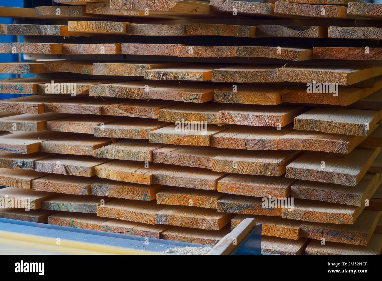 Holzbretter werden in einem Sägewerk oder einer Schreinerei gestapelt. Sägen Trocknen und Vermarktung von Holz. Industrieller Hintergrund. Stockfoto