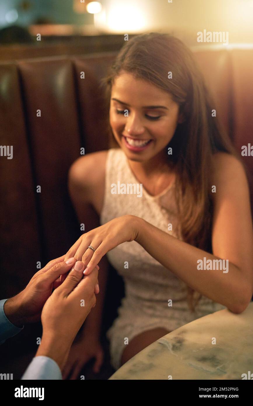 Der Moment, an den sie sich für immer erinnern würden. Eine junge Frau verlobt sich während eines romantischen Dinner in einem Restaurant. Stockfoto