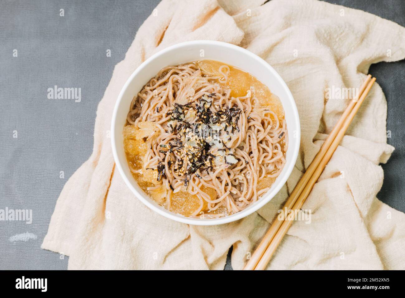 Koreanische Küche Naengmemilguksu, eine winterliche Delikatesse, wird dieses Buchweizen-Nudelgericht in einer kalten Hühnchen- oder Rinderbrühe serviert und mit einer kalten Scheibe garniert Stockfoto