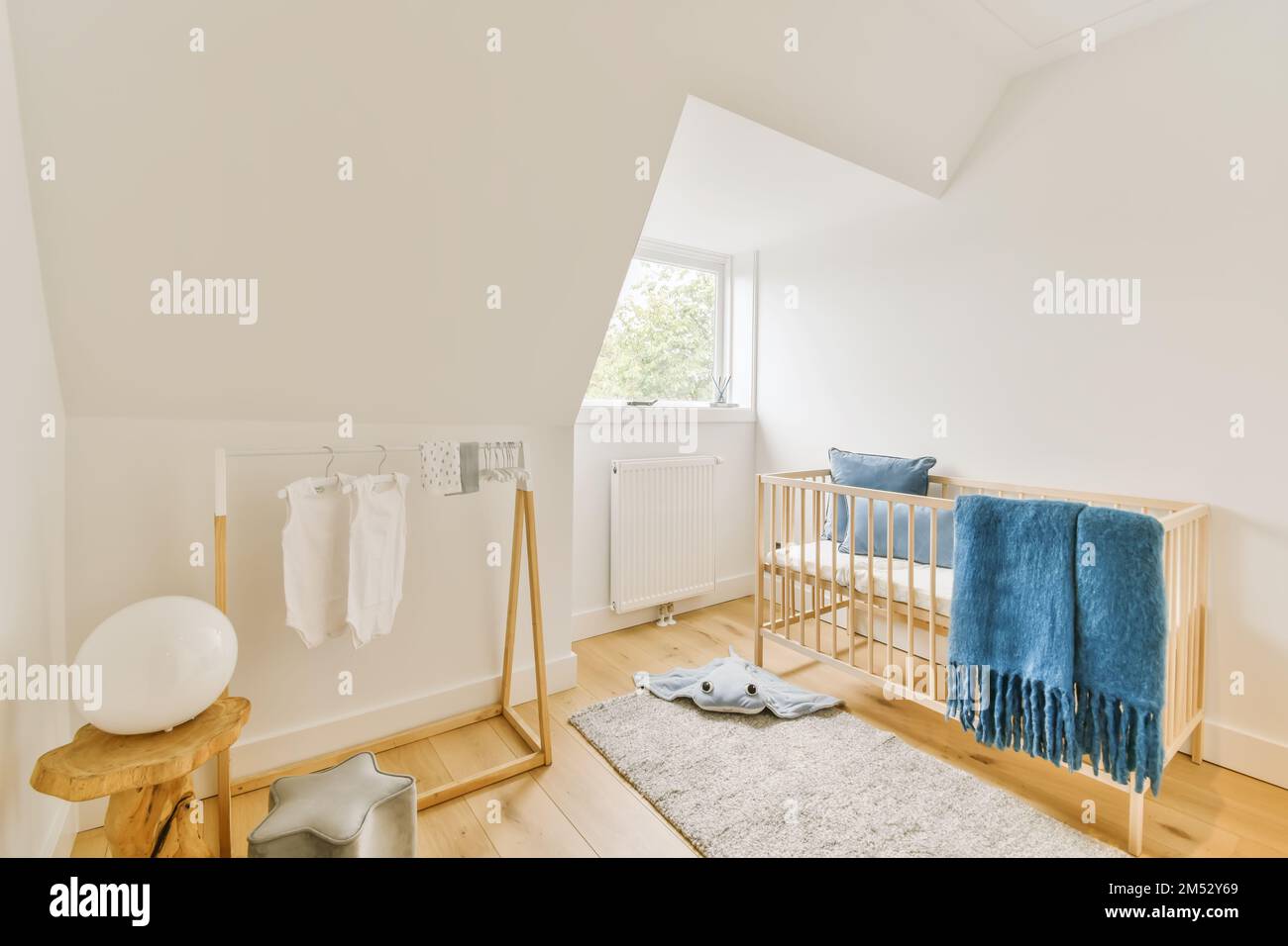 Ein Kinderzimmer mit einem Kript und einer blauen Decke, die an der Wand neben dem Kript hängt Stockfoto